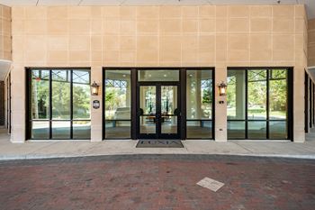 A building with a tan wall and black doors.